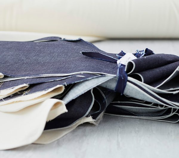 A collection of cut denim to the size is shown on a desk in a studio