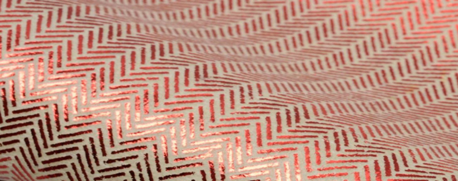 Sample of an un-woven fabric with red print repeat on top